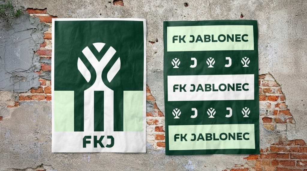 Two posters on a weathered brick wall: a large green apple-tree symbol with FKJ, and stacked FK JABLONEC bands with the J and tree.