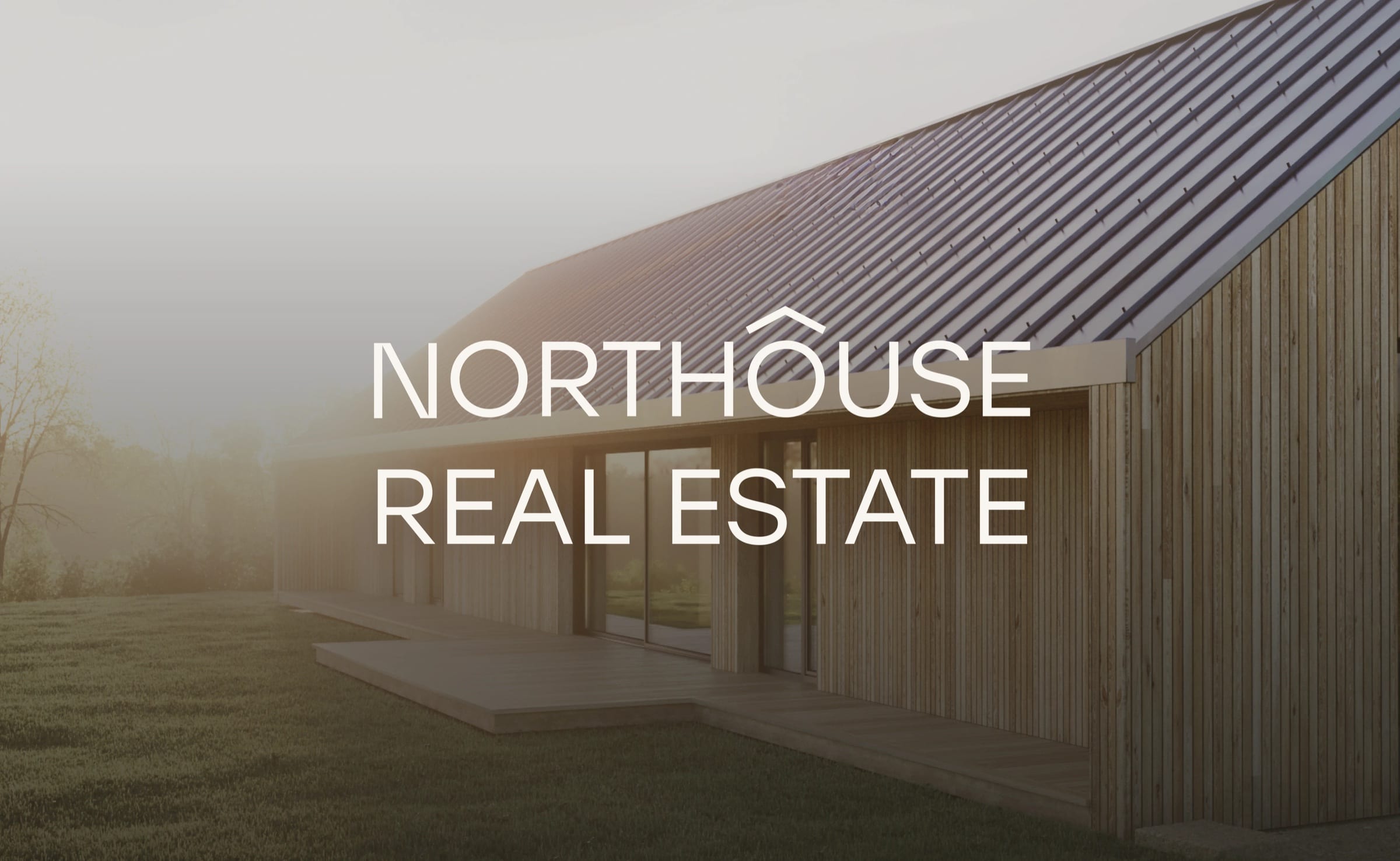 NORTHOUSE REAL ESTATE in white over a timber house with a standing-seam roof in soft morning mist.