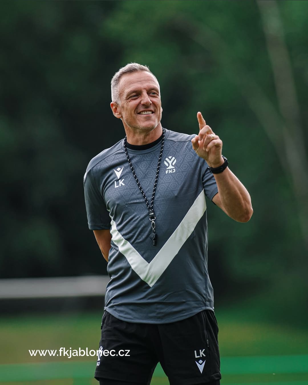 The coach in the new grey training kit with the chevron and the symbol.