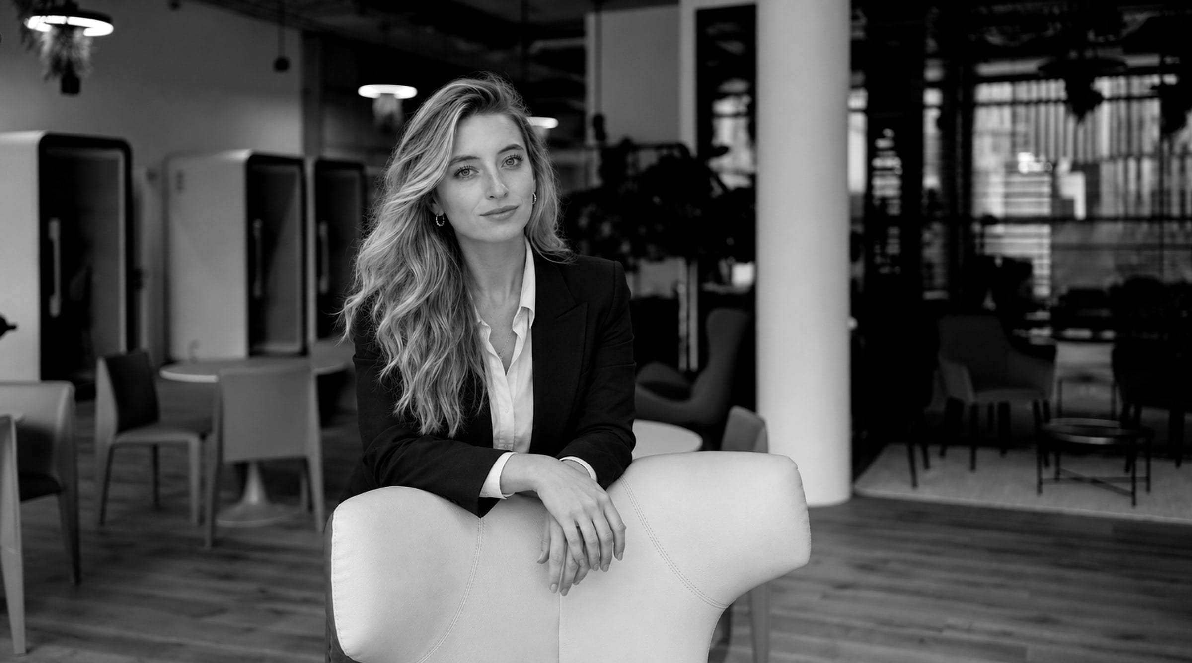Lucie Krulich, product and design leader in Prague, in a dark blazer in an open office, black and white portrait.