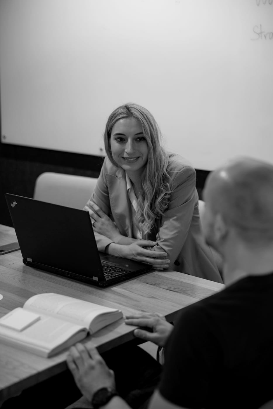 Lucie Krulichová listening to a client across a table, laptop open, in Prague.